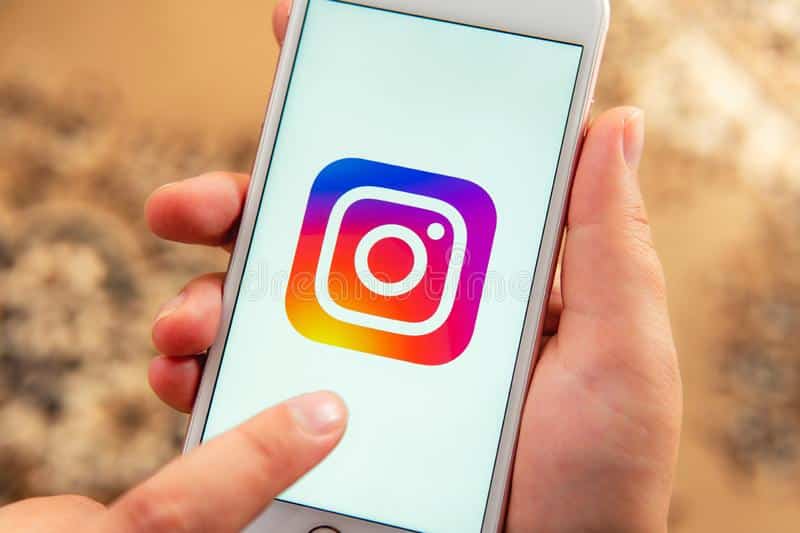 main-femelle-avec-le-téléphone-d-apple-logo-des-médias-sociaux-instagram-palo-alto-etats-unis-août-sur-l-écran-ic-ne-sociale-155524223